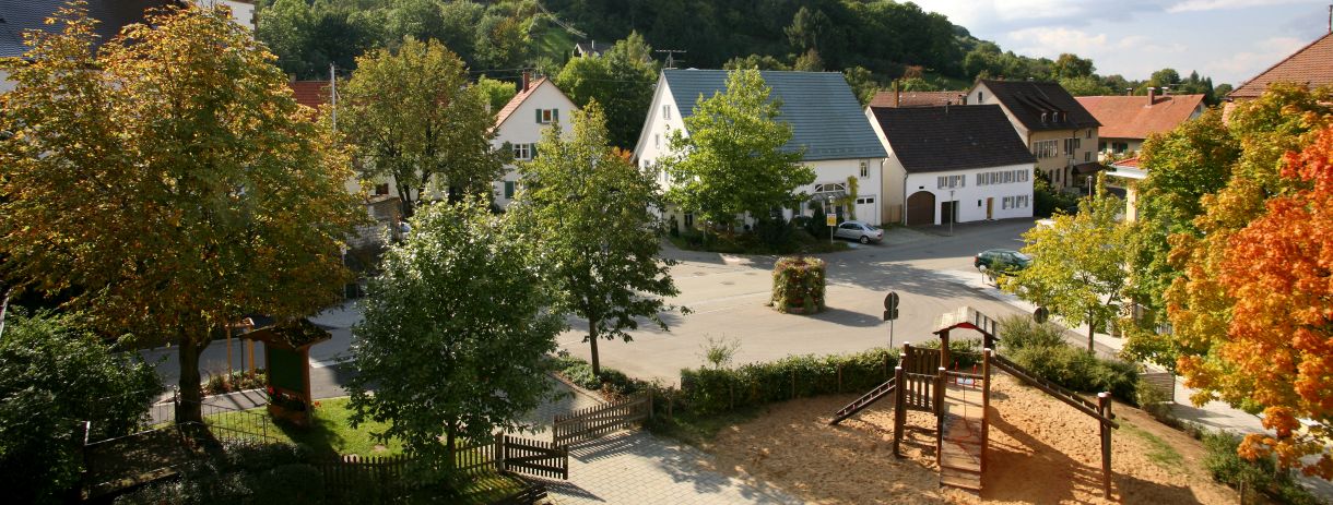 Häuser und Spielplatz mit Bäumen umgeben