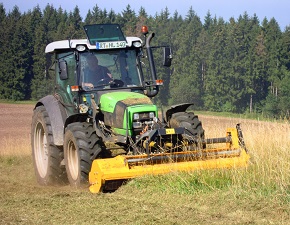 Traktor mit Mulchgerät beim Mulchvorgang