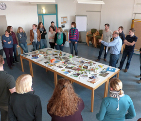 Fortbildungsteilnehmer stehen um einen Tisch herum
