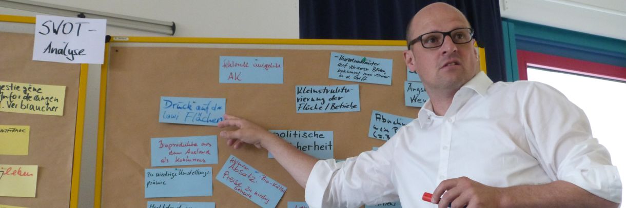Fortbildungsteilnehmer steht vor einer Metaplanwand