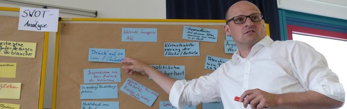 Fortbildungsteilnehmer steht vor einer Metaplanwand